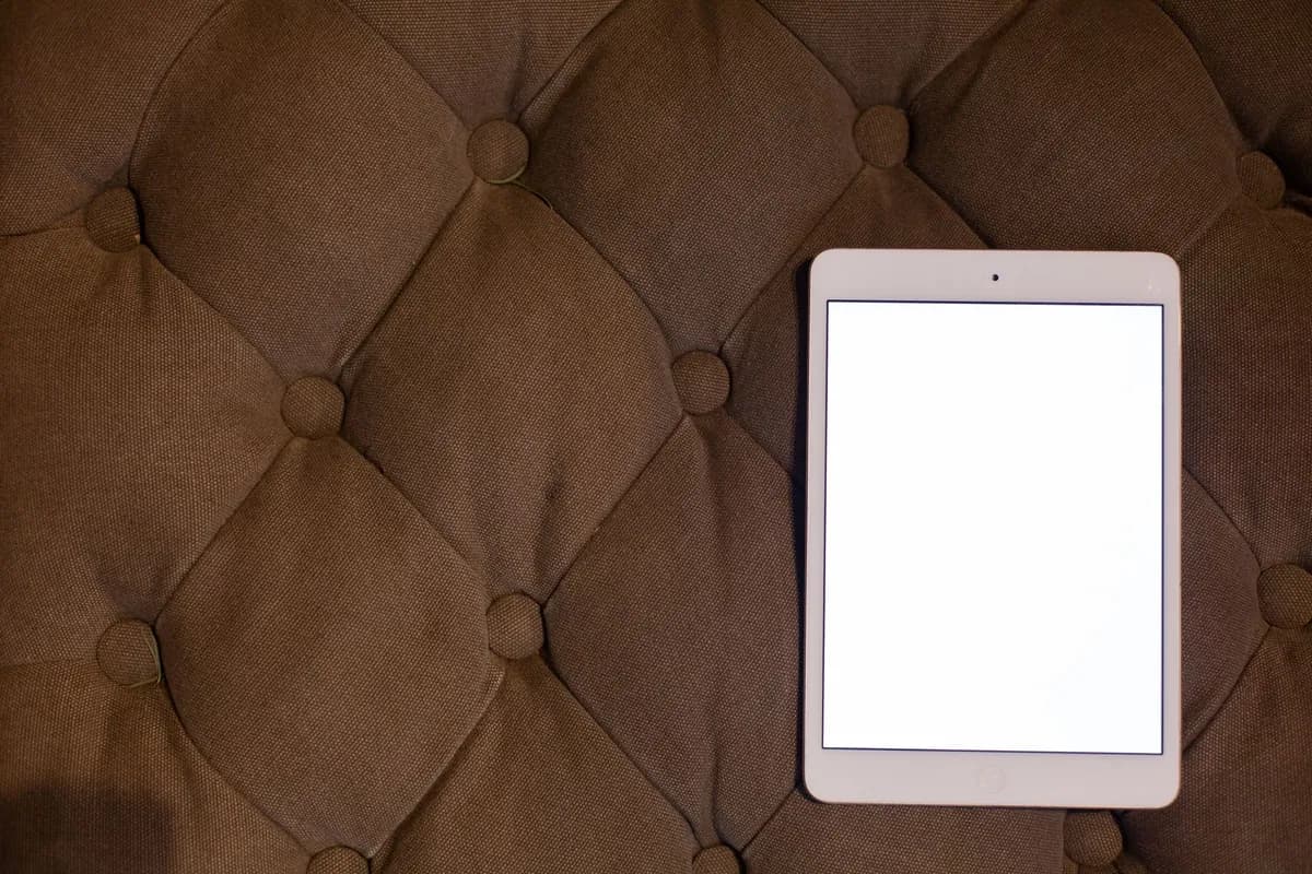 Tablet mit leerem Bildschirm auf einem braunen Polsterkissen