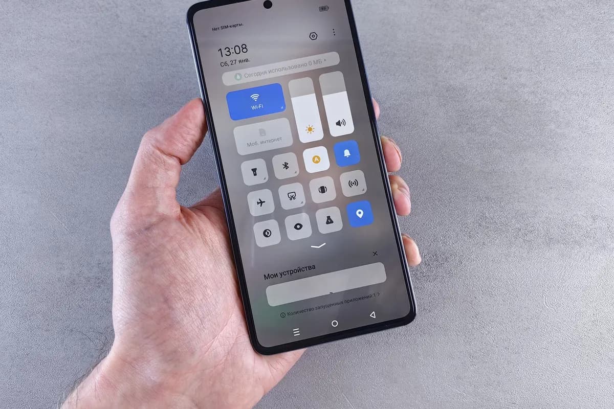Hand hält ein Smartphone mit geöffneten Schnelleinstellungen