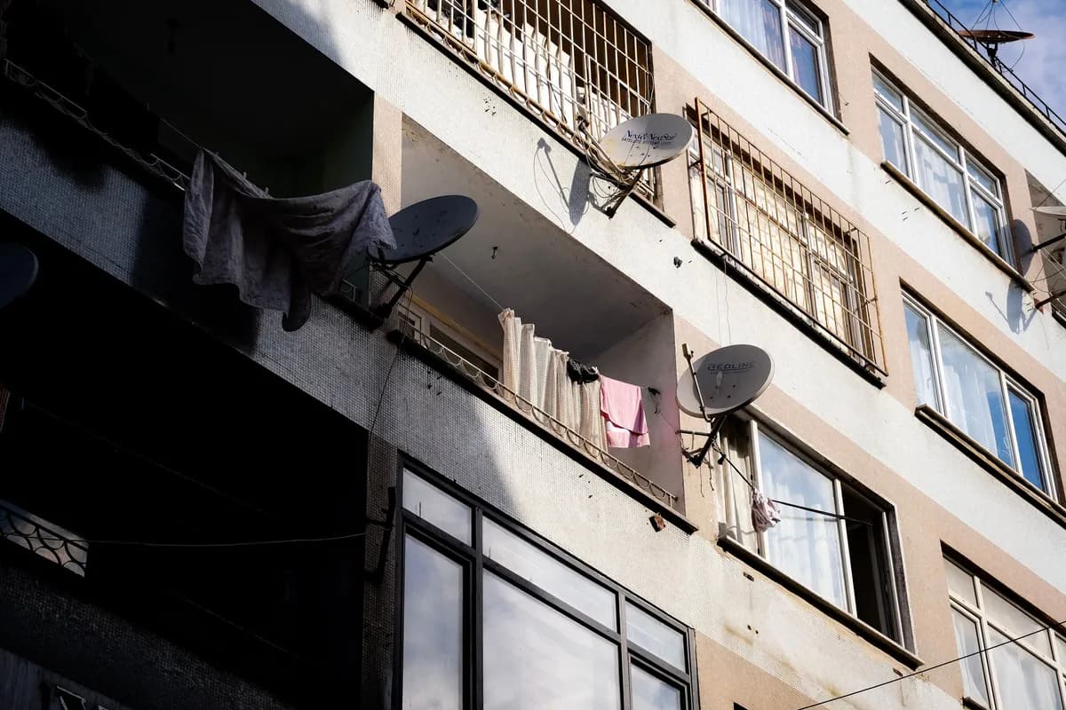 Satellitenschüsseln an den Balkonen eines Mehrfamilienhauses